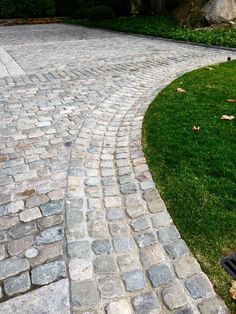 a brick walkway in the middle of a grassy area