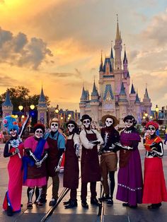 a group of people dressed up in skeleton costumes posing for a photo at disney world