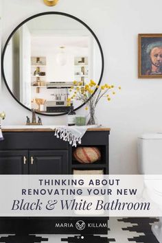 a white bathroom with black and white flooring, a round mirror above the sink