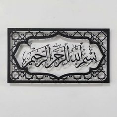 an arabic sign hanging on the side of a white wall with black writing in it