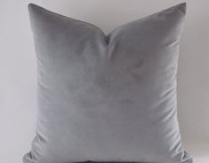 a gray pillow sitting on top of a white table