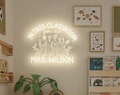 this classroom is decorated with neon signs and pictures on the wall, along with a potted plant