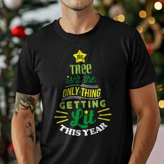 Celebrate the holiday season with a sense of humor with this "The Tree Isn't The Only Thing Getting Lit Christmas T-Shirt." This funny and festive shirt is perfect for holiday parties, gatherings, or as a fun gift for friends and family. The design features a Christmas tree graphic with a playful message, making it a great addition to your holiday wardrobe. Made from high-quality materials, this t-shirt offers comfort and durability throughout the season. Spread some holiday cheer and laughs wit Christmas Tree Shirts, Holiday Tees, Funny Holiday Shirts, Christmas Tree Graphic, School Supplies Shopping, Christmas Party Shirts, Christmas Tree Shirt, Tree Graphic, Festival Shirts