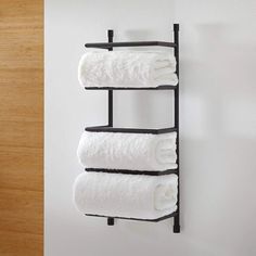 three white towels are hanging on a towel rack