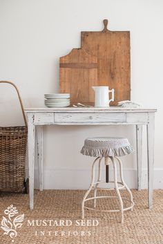 a white table with plates and cups on it next to a wooden chair in the corner