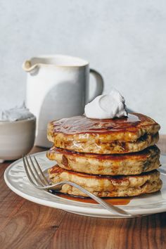 stack of pancakes with syrup and whipped cream