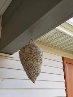 a bird feeder hanging from the side of a house