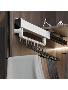 a rack with clothes hanging on it next to a closet door and some folded towels