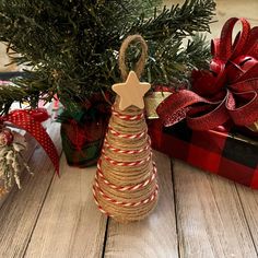 a small christmas tree is wrapped in twine and tied with jumbo rope, next to a gift box