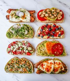 six different types of sandwiches on a marble counter top, each with various toppings