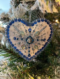 a heart shaped ornament hanging from a christmas tree