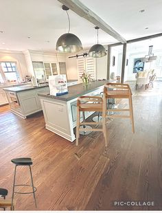 a large kitchen with an island and bar stools in it's center area