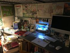 a cluttered desk with a computer monitor and keyboard