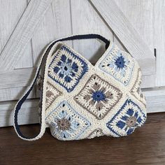 a crocheted purse sitting on top of a wooden floor next to a door