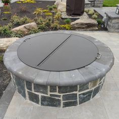 an outdoor fire pit in the middle of a garden