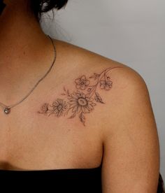 a woman wearing a black dress has a sunflower tattoo on her chest