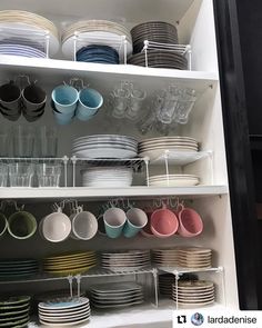 the shelves are full of dishes and cups in different colors, shapes and sizes on them