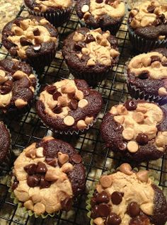 chocolate cupcakes cooling on a wire rack with peanut butter and chocolate chip toppings