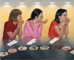 three women sitting at a table with food on it