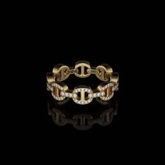 a gold and diamond ring on a black background