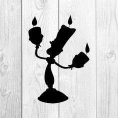 a black and white silhouette of a person holding a candle on top of a table