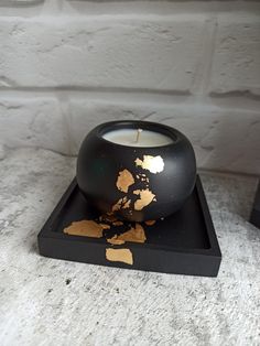 a black candle holder with gold paint on it