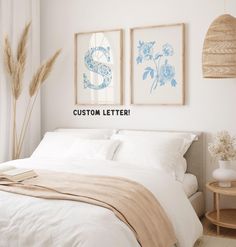 a bed with white sheets and pillows in a room next to two pictures on the wall