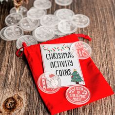 a red bag filled with coins sitting on top of a wooden table next to christmas decorations