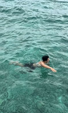 a man swimming in the ocean with his arm out