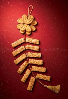 cookies are arranged in the shape of a christmas tree on a red background with gold flakes