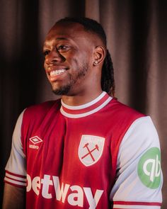 a man in a red and white shirt is smiling