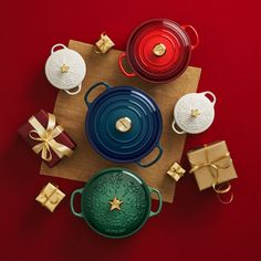 christmas presents are laid out on a table with red and green plates, wrapped in gold ribbon