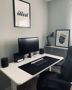 a white desk with a black chair and computer monitor on it in an office setting