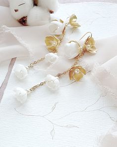 Delicate feminine wedding boho earrings. Earrings are fully handmade of gold-plated brass elements and hand-created foam flowers with tiny pearls in the middle, placed on the delicate chain. ❤️ earrings length 3.5 inches (9 cm) ❤️ earrings width 0.6 inch (1,5 cm) ❤️ earrings are very light weight and comfortable ❤️ made of gold-plated brass elements, tiny chain and hand crafted flowers ❤️ antiallergic nickel-free ear wire ❤️ different color option available - ask for details ❤️ ships within 5 da Elegant Brass Chandelier Earrings With Latkans, Yellow Gold Brass Drop Bridal Earrings, Delicate Gold Jewelry For Celebration, Delicate Gold Jewelry For Festive Occasions, Gold Plated Bridal Dangle Earrings For Celebration, Yellow Gold Drop Bridal Earrings In Brass, White Gold Plated Bridal Earrings For Celebration, Delicate Chandelier Earrings For Party, Handmade Chandelier Earrings For Wedding