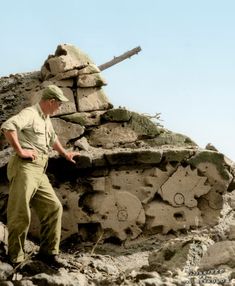 a man standing next to a pile of rocks