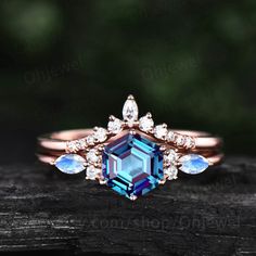 a blue and white diamond ring on top of a piece of wood