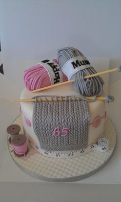 a cake decorated with yarn and knitting needles