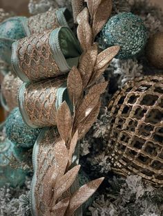 a close up view of some ornaments on a christmas tree with gold and blue decorations