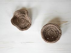 two crocheted baskets sitting on top of a white wooden floor