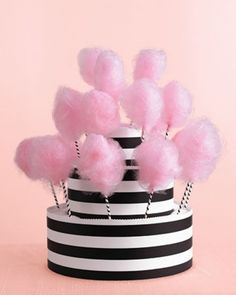 a black and white striped hat with pink pom - poms on the top