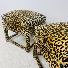 two leopard print foot stools sitting next to each other on top of a white floor