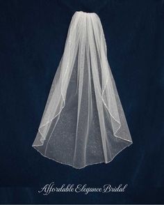 the veil is white with sparkles on it and sits in front of a dark background