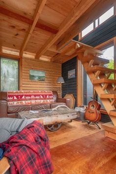 a living room filled with furniture and lots of wood flooring next to a stair case