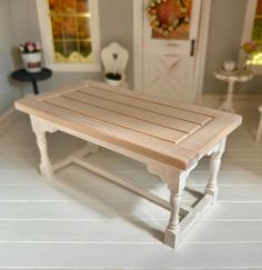 a doll house with a wooden table and chairs in it's living room area