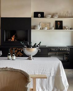 a dining room with a table and chairs in front of an open fire place that is built into the wall