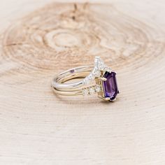 an image of two rings with amethorate and diamonds on wood table background