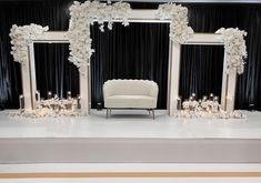 a white couch sitting in front of a mirror on top of a floor next to candles