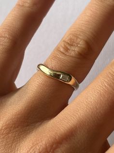 a woman's hand with a gold wedding ring on top of her left hand