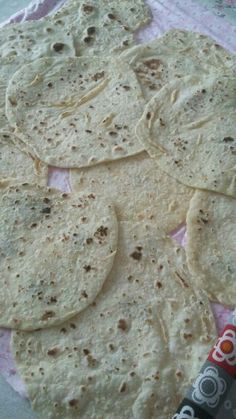 several tortillas on a pink and white cloth with a candy bar in the background