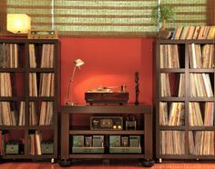 there is a record player in the center of this bookcase with many records on it